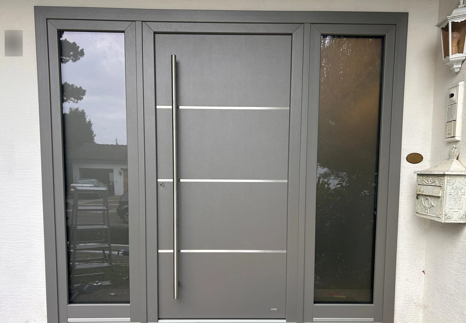 Haustür aus Aluminium mit zwei Seitenteilen und horizontalen Zierleisten